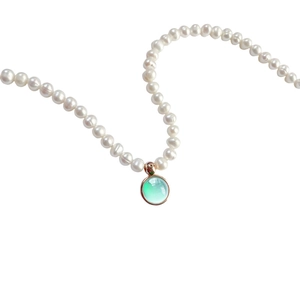 Vintage pearl necklace with a light green gemstone pendant in rose gold setting