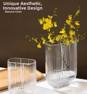 Detailed close-up of U-shaped glass vase with vertical fluted texture and polished finish