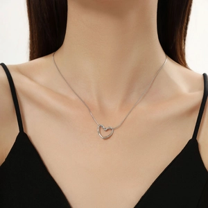 Dettaglio di una collana con ciondolo a cuore argento indossata per riferimento misura