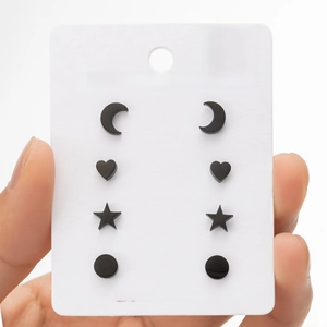 Detail of four pairs of black stainless steel geometric stud earrings on card