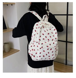Corduroy backpack with strawberry print shown on model to display size and fit