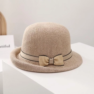 Detailed view of women's woven sun hat with bow tie ribbon and black brim edging