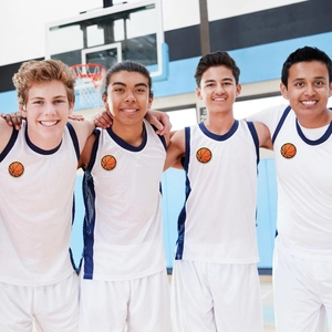 White basketball jersey set with blue trim and embroidered patch in an indoor court scene