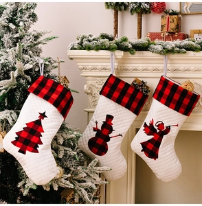 Drei hochwertige gesteppte Weihnachtssocken mit rot-schwarz karierten Details am Kamin