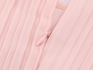 Detail shot of the invisible zipper and pleated pink fabric on this elegant chiffon dress