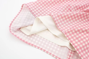 Close-up of pink and white plaid fabric with neat white inner lining details