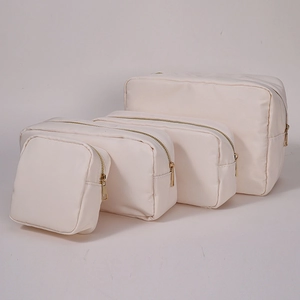 Set of four cream nylon makeup bags in various sizes with premium gold zippers