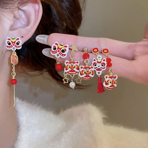 Détail des boucles d'oreilles festives danse du lion avec pompons rouges et perles