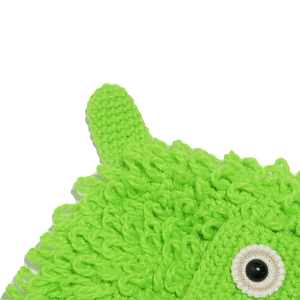 Close-up of green hand-crocheted hat texture with 3D eye detail and knitted horn