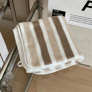 Close-up of thick striped bath towel with reinforced edges on a minimalist metal rack