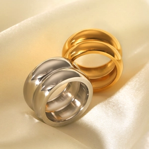 Polished 18K gold and silver double-layer stainless steel rings on silk background