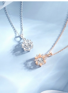 Close-up of silver and rose gold sunflower necklaces with round-cut sparkling stones