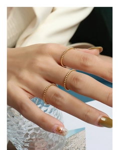 Detailed view of stacked 18k gold beaded rings with a minimalist French style texture