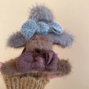 Detail of plush bow claw clip featuring soft faux fur and thick knitted texture