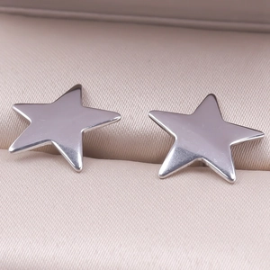 Close-up of polished silver star earrings on a soft pink jewelry box display