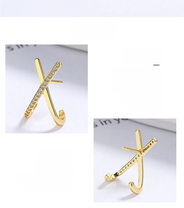 Detailed view of gold X-shaped crisscross stud earrings featuring micro-pave white zircons
