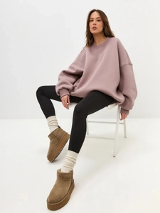 Close-up of mauve oversized fleece sweatshirt paired with brown platform suede boots