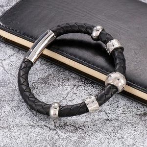 Gros plan du bracelet en cuir tressé noir avec fermoir magnétique et perles en acier