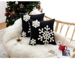 Detailed view of black plush pillow covers with white snowflake embroidery for Christmas