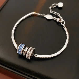 Detail of silver bracelet with blue zircon beads and engraved LOVE charm on leather