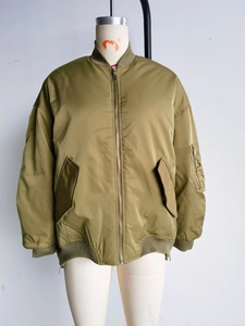 Detail of olive green bomber jacket featuring sleeve utility pocket and ribbed cuffs
