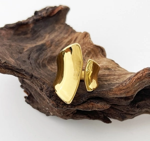 Detailed view of large gold metallic chunky ring with smooth organic curved surface