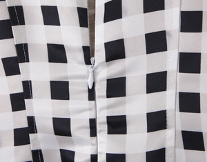 Detail of the invisible back zipper on a black and white plaid sleeveless dress