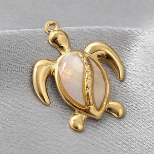 Macro detail of golden turtle pendant with iridescent shell inlay and smooth metallic finish