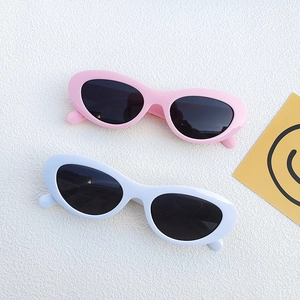 Retro oval sunglasses in pink and white frames with black lenses for a trendy summer look