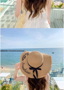 Detail of straw sun hat with Hello Sunshine embroidery and black ribbon bow decoration