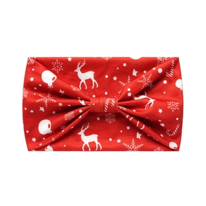 Detail of red Christmas headband featuring white reindeer, snowflake and candy cane patterns