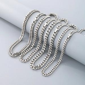 Polished silver stainless steel Cuban link chains in various widths on grey pedestals