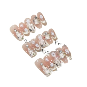 Handmade press-on nails featuring winter snowflake patterns with cat eye effect and rhinestones