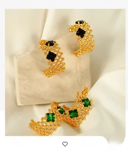 Détail de boucles d'oreilles C plaquées or 18K avec texture mesh et pierres carrées