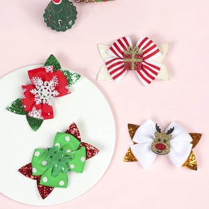 Macro detail of four glittery Christmas bow hair clips with festive patterns and sequins