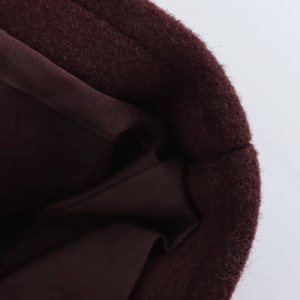 Gros plan de la veste bordeaux montrant la texture douce du tissu et la doublure intérieure