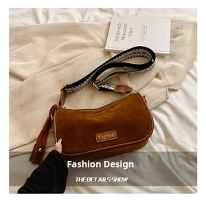 Close-up of brown suede hobo bag featuring a retro geometric woven wide shoulder strap
