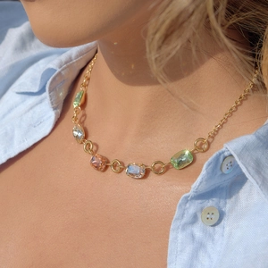 Elegante collana in acciaio al titanio dorato con cristalli colorati su modella
