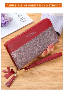 Detail of red leather long wallet with pink sequins, zipper closure and tassel wristlet