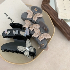 Detailed close-up of premium acetate bow hair claws in elegant black and grey patterns
