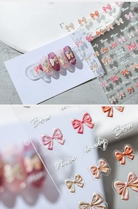Macro detail of 3D embossed nail stickers featuring elegant bows and decorative letters
