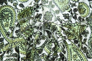 Detail of green and white paisley print blouse featuring front tie and crinkled fabric texture