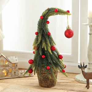 Miniature green snow-covered Christmas tree with red berries in a vintage pot