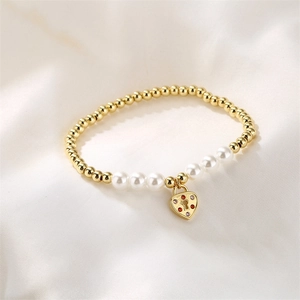 Detalle de pulsera de cuentas con esferas doradas, perlas y dije de candado de corazón