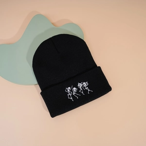 Vue détaillée de la broderie squelette dansant sur un bonnet en tricot noir