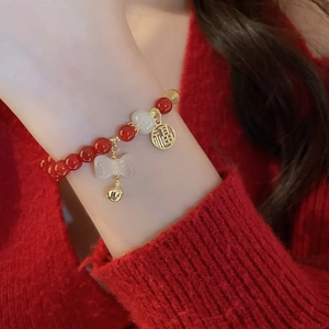 Détails de perles de cinabre rouge, breloque nœud blanc et pendentif doré Fu sur le bracelet