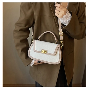 Détail du sac selle blanc et beige en cuir litchi avec fermoir doré métallique