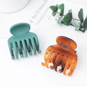 Matte green and amber hair claws in medium size shown with a decorative leaf
