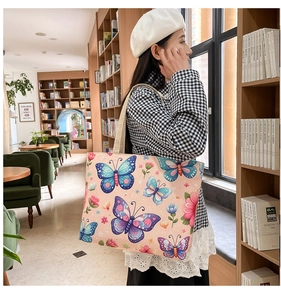 Close-up of ethnic floral canvas tote bag with butterfly prints in a library setting