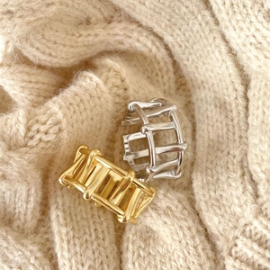 Detailed macro view of 925 silver hollow rings on beige knitted fabric texture